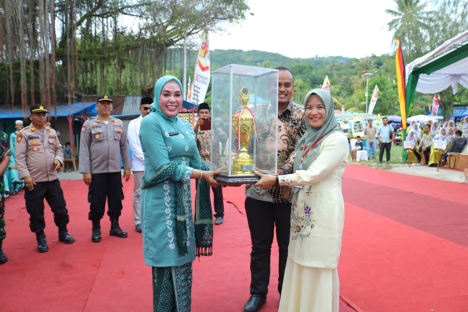 Ketua TP PKK Kabupaten Solok, Ny.Hj.Emiko Epyardi Asda menyerahkan piala juara umum Jambore Kader PKK Berprestasi Tingkat Kabupaten Solok kepada Ketua TP PKK Kecamatan X Koto Singkarak